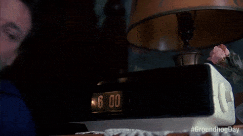 Çalar saatine kızgın adam onu yumrukluyor.