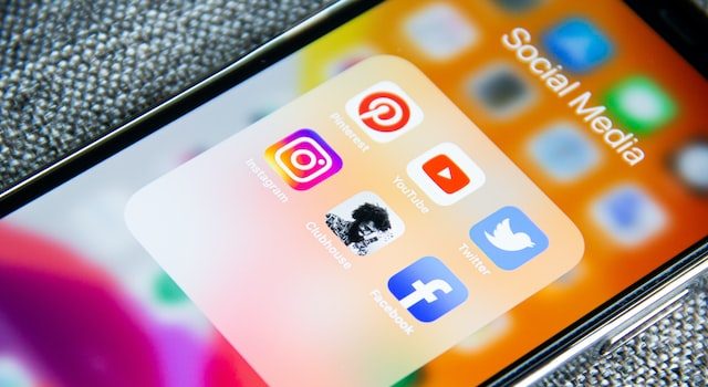 Üzerinde sosyal medya uygulamalarının açık olduğu bir klasör bulunan akıllı telefon