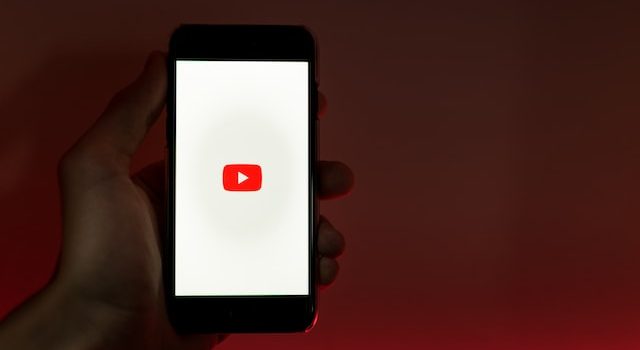 Üzerinde YouTube uygulaması açık olan bir akıllı telefon tutan kişi