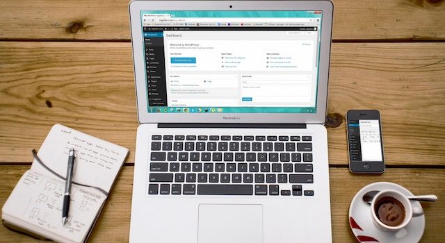 แล็ปท็อปที่มีแดชบอร์ดผู้ดูแลระบบ WordPress เปิดอยู่บนโต๊ะไม้