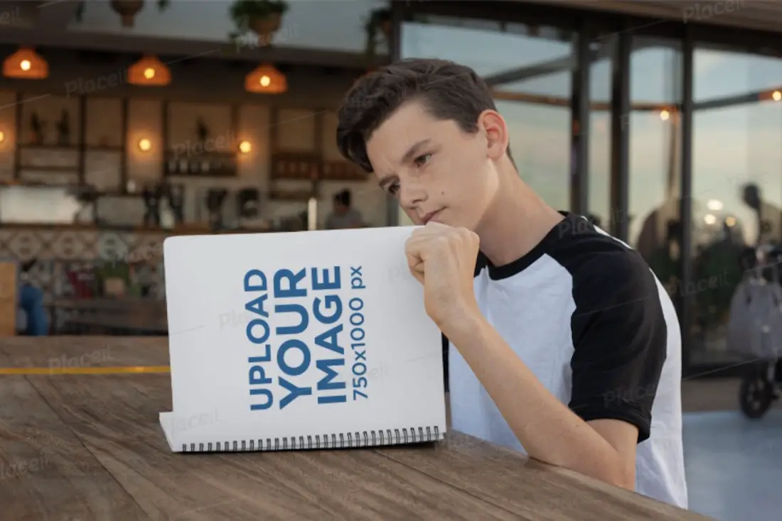 menino lendo maquete de caderno