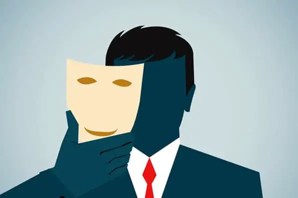 Una persona che ha a che fare con la sindrome dell'impostore rimuove una maschera dietro cui si nascondeva.