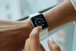 Jam tangan pintar di pergelangan tangan wanita.