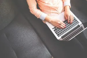 Une femme travaillant sur un ordinateur portable, essayant de créer un site Web de blog.