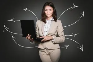 Une femme tenant un ordinateur portable sur le point de migrer votre site WordPress vers un nouvel hébergeur.