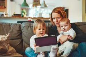 Una madre con bambini e un tablet.