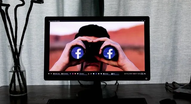Człowiek w telewizji patrzący przez lornetkę, aby znaleźć najlepsze wtyczki WordPress do Facebooka, aby rozwijać swój blog.