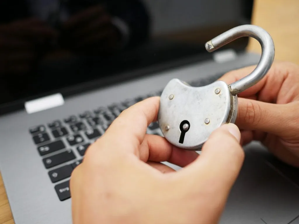 Tenendo un vecchio lucchetto davanti a un laptop.