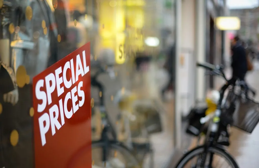 Uma placa vermelha mostrando a oferta “Preços especiais” em uma loja.