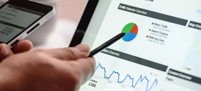 Googleアナリティクスを指すペンを持っている手。