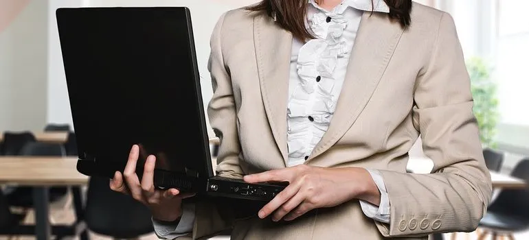 ノートパソコンを持ってウェブサイトの管理に集中する準備をしている女性