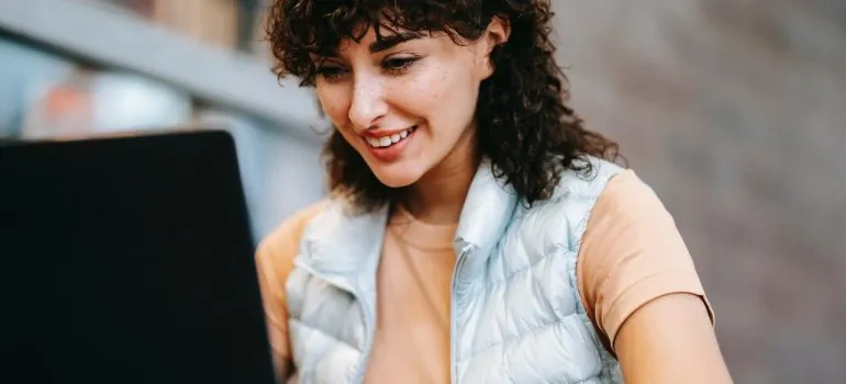 امرأة مبتسمة على جهاز كمبيوتر محمول.