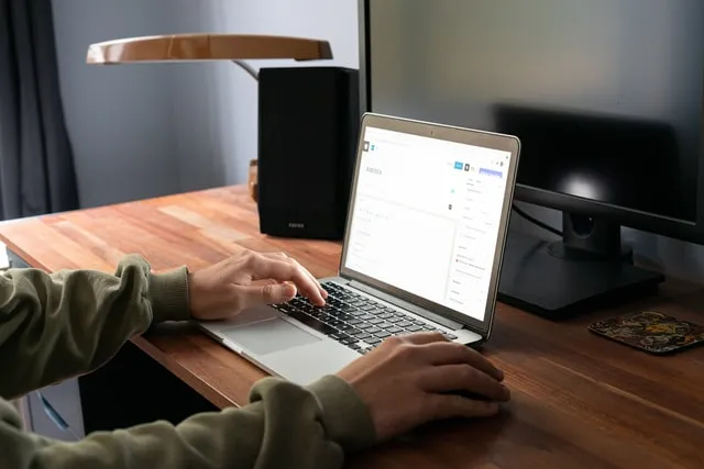 Una persona seduta alla propria scrivania che legge come configurare il monitoraggio delle e-mail di WordPress su un laptop