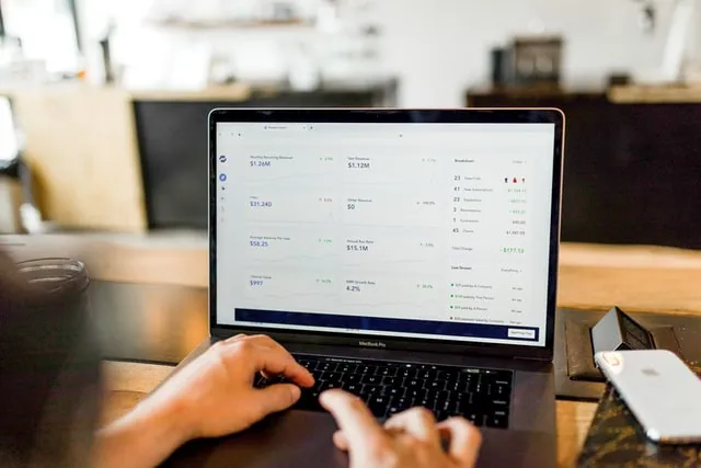 Una persona che digita su un laptop e guarda uno schermo con statistiche e-mail