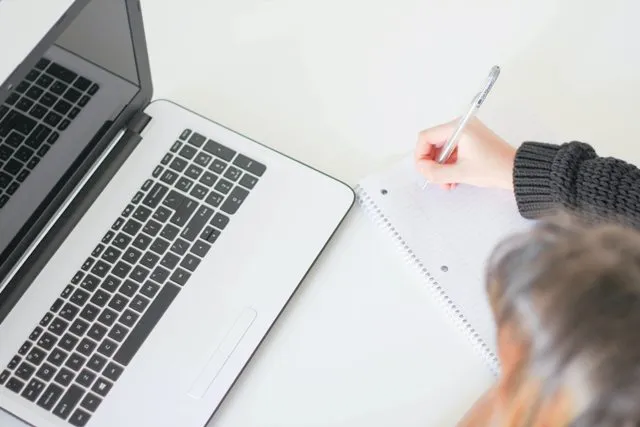 Una donna che prende nota dei cambiamenti sul suo sito WordPress.