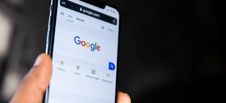 Uma pessoa segurando um telefone com uma página do Google aberta nele