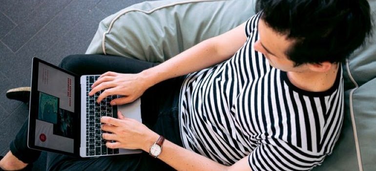 Mann, der auf einem grauen Stuhl sitzt und ausgewählte Bilder für seinen Blog-Beitrag in WordPress auswählt