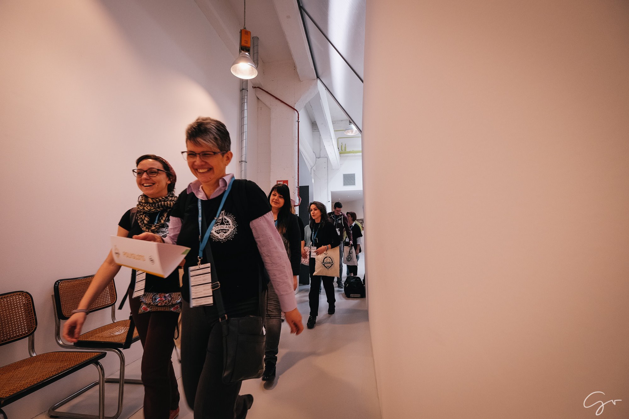 Mulheres andando no corredor durante WordCamp Torino