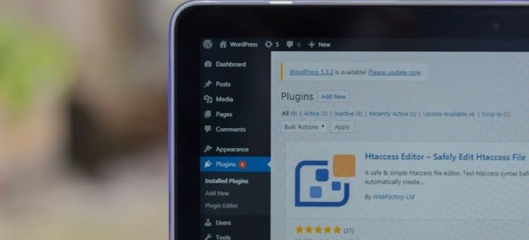 Linke rechte Ecke eines Laptops mit geöffnetem WordPress-Dashboard und Plugins