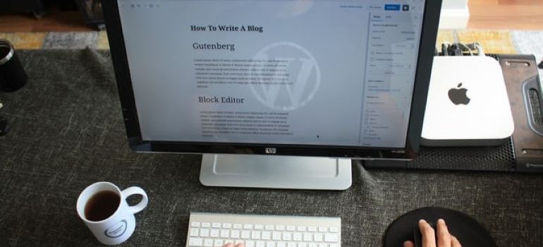 Человек, пишущий блог в WordPress, открытый на iMac