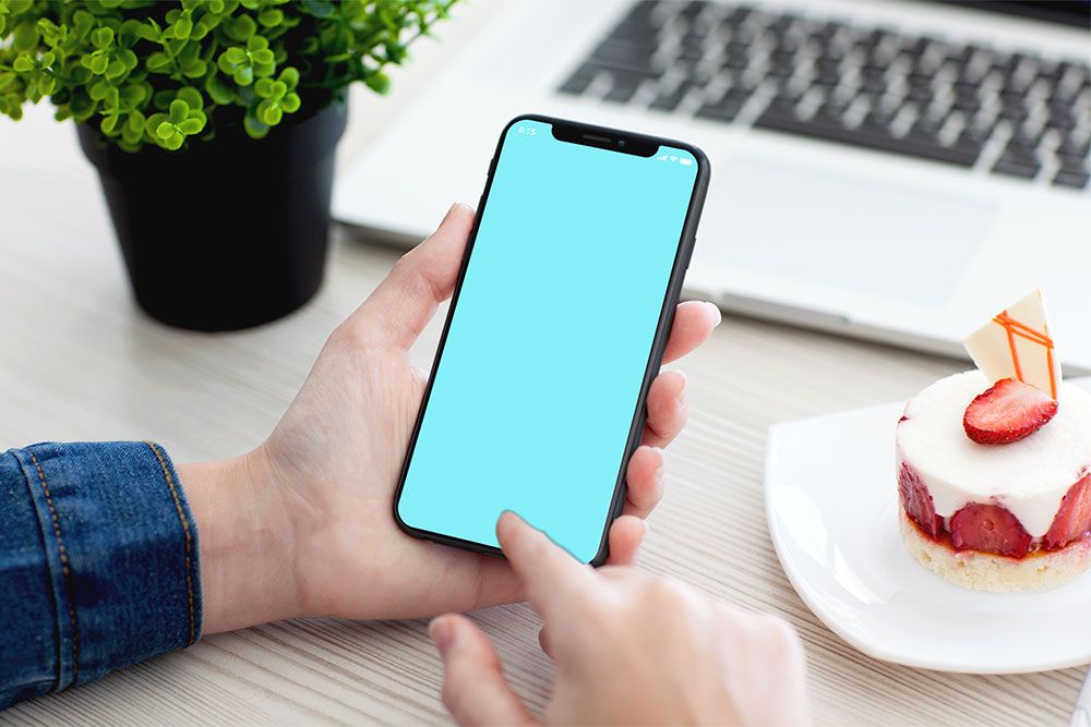拿着 iphone x psd 样机的男性手