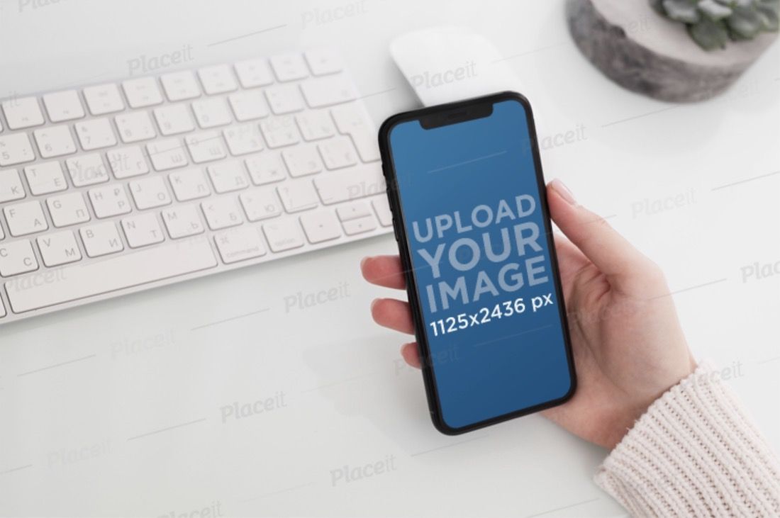 一个女人的手拿着 iphone 11 pro 放在整洁的桌子上的模型