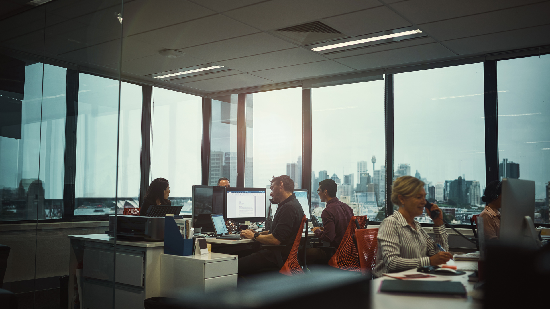 oficina con trabajadores en computadoras en escritorios