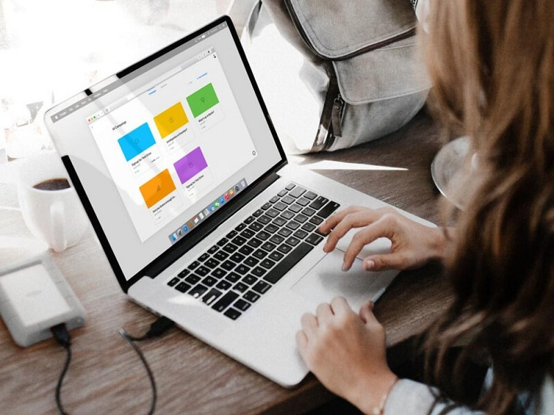 在 MacBook 上工作的年轻女子
