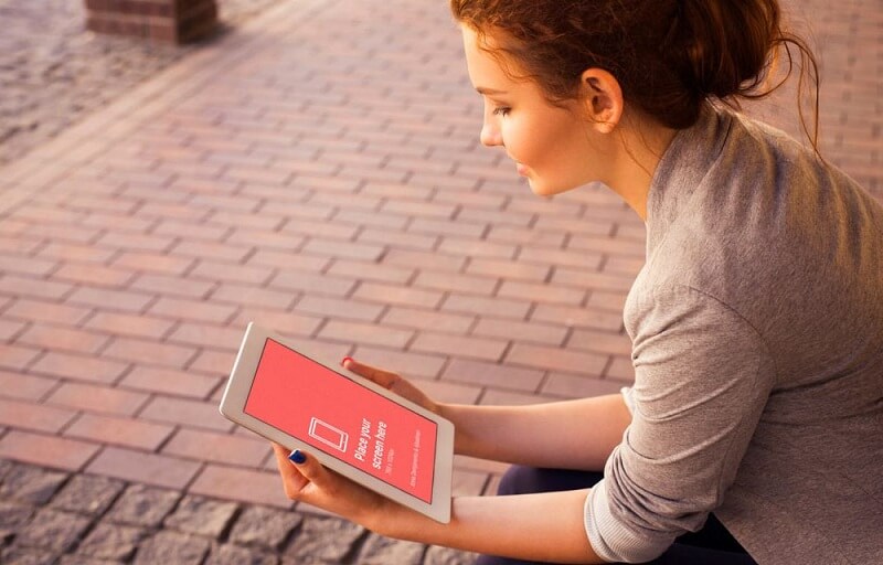 Junge Frau, die iPad betrachtet