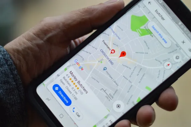 Person mit einem Smartphone, auf dem Google Maps geöffnet ist